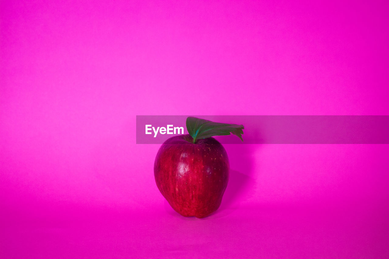 CLOSE-UP OF FRUIT AGAINST PINK OVER COLORED BACKGROUND