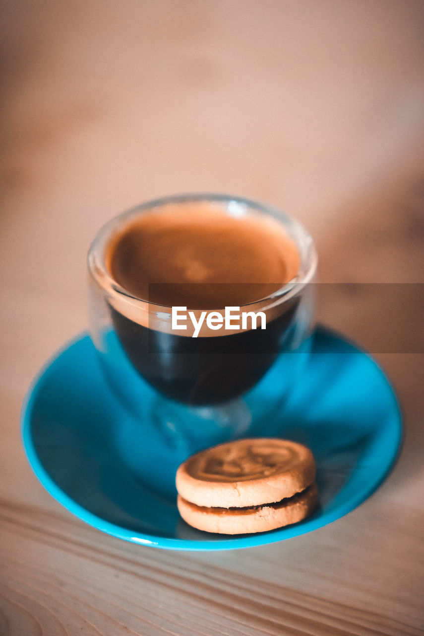 Close-up of coffee in cup with cookie on table