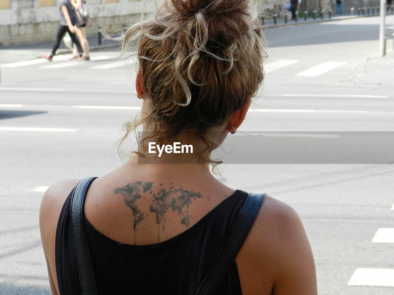 Rear view of woman with world map tattoo on back