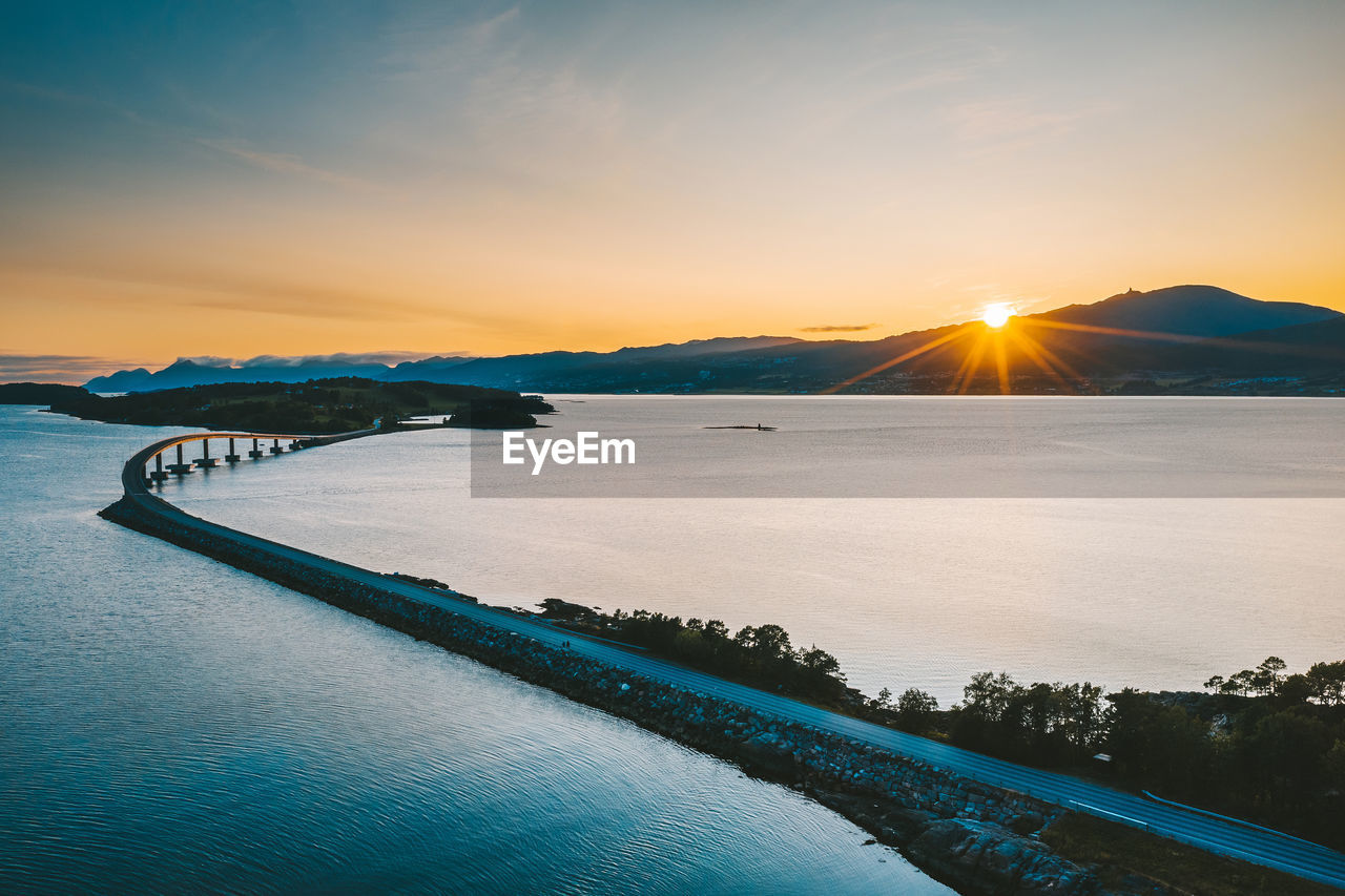 Scenic view of bridge over sea against sky during sunset