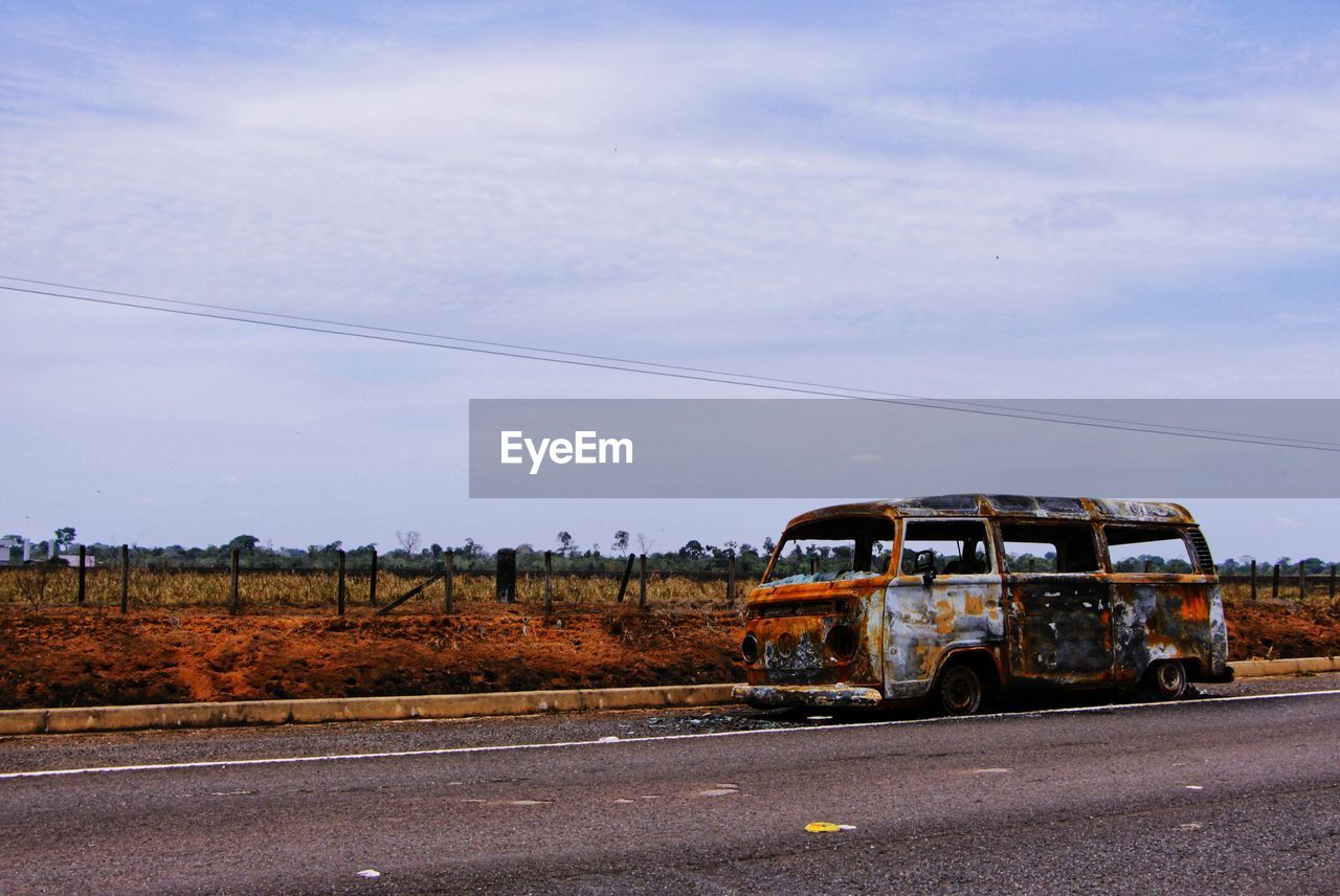 Abandoned van on road against sky