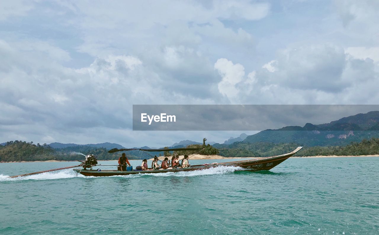 PEOPLE ON BOAT AGAINST SEA