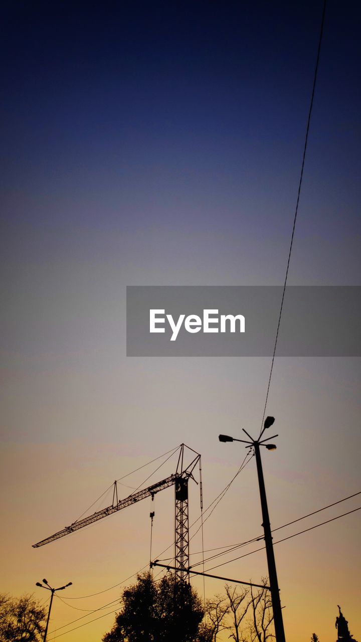 LOW ANGLE VIEW OF SILHOUETTE ELECTRICITY PYLON AGAINST CLEAR SKY
