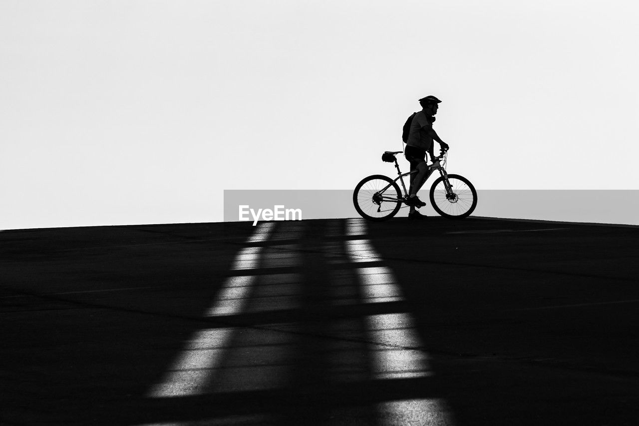bicycle, transportation, sports, black, one person, cycling, riding, black and white, full length, motion, white, lifestyles, vehicle, monochrome, shadow, activity, mode of transportation, leisure activity, stunt, monochrome photography, copy space, silhouette, men, nature, sunlight, cycle sport, land vehicle, on the move, sky, side view, helmet, adult, headwear, day, speed, bicycle motocross, skill, outdoors, sports equipment