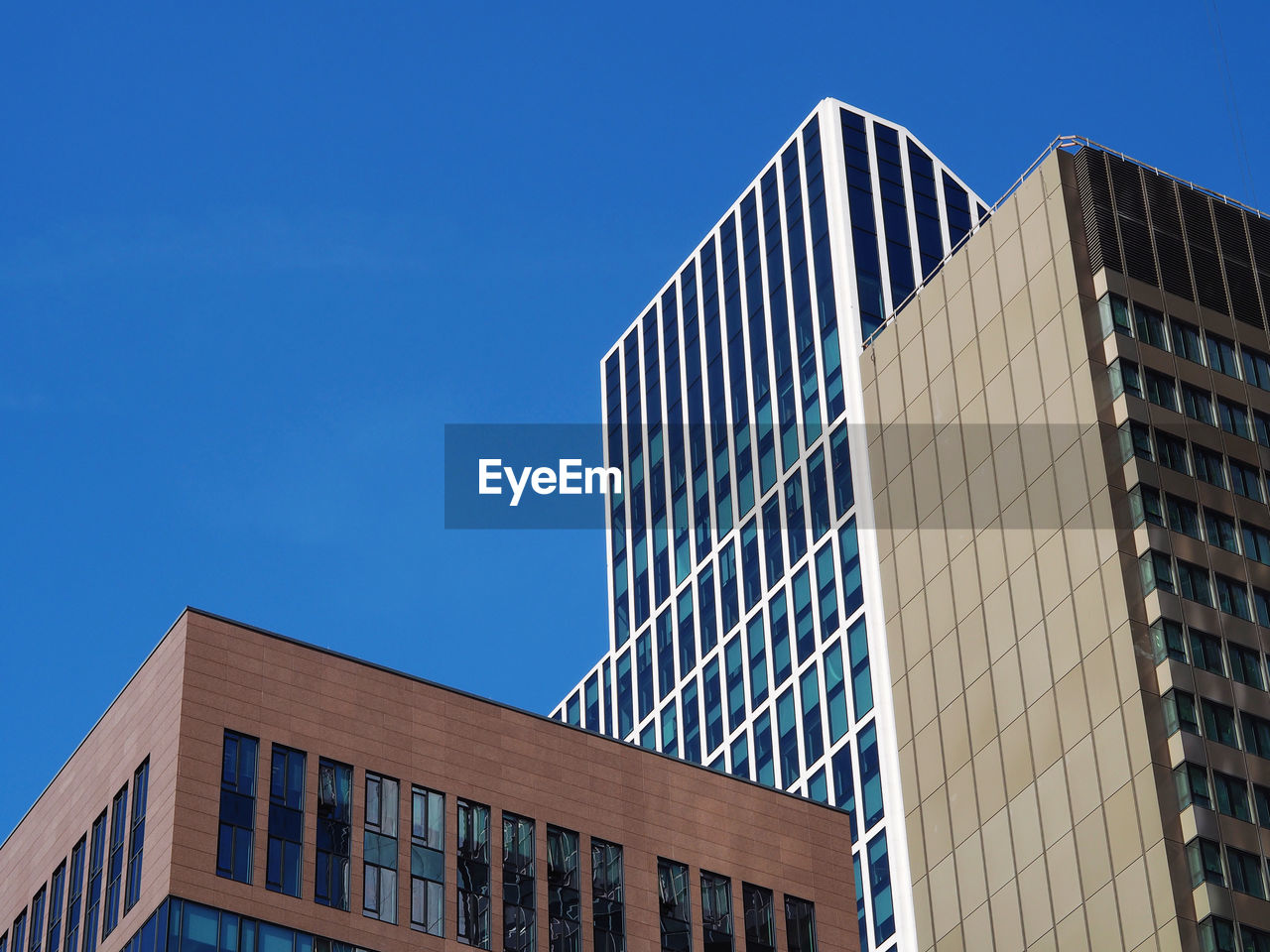 Low angle view of modern building against clear blue sky