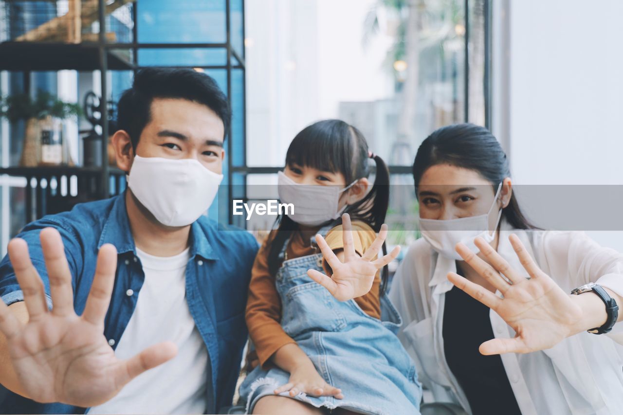 Portrait of smiling family gesturing while sitting at home