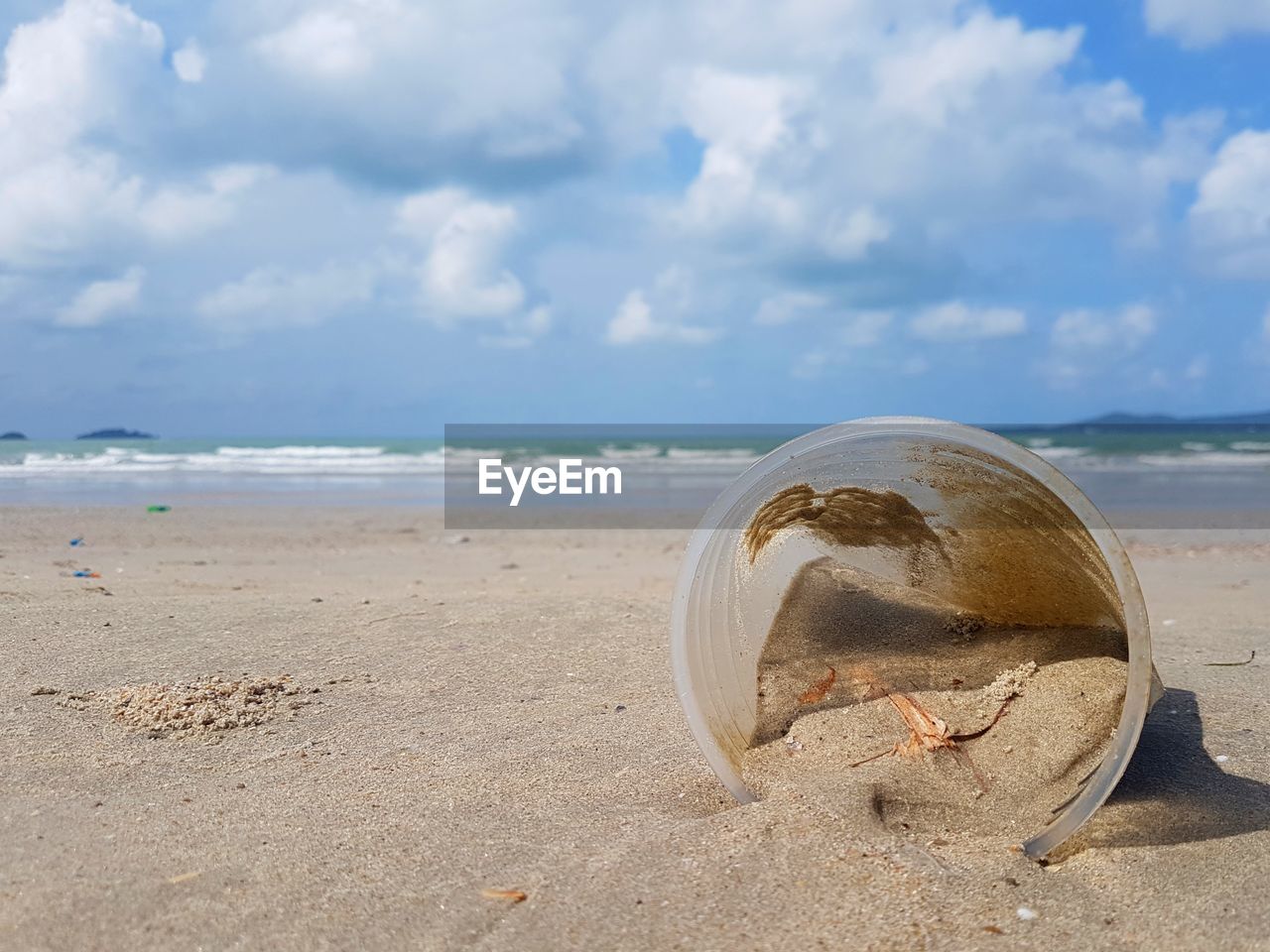 Plastic glass at the beach. pollution of environment by human