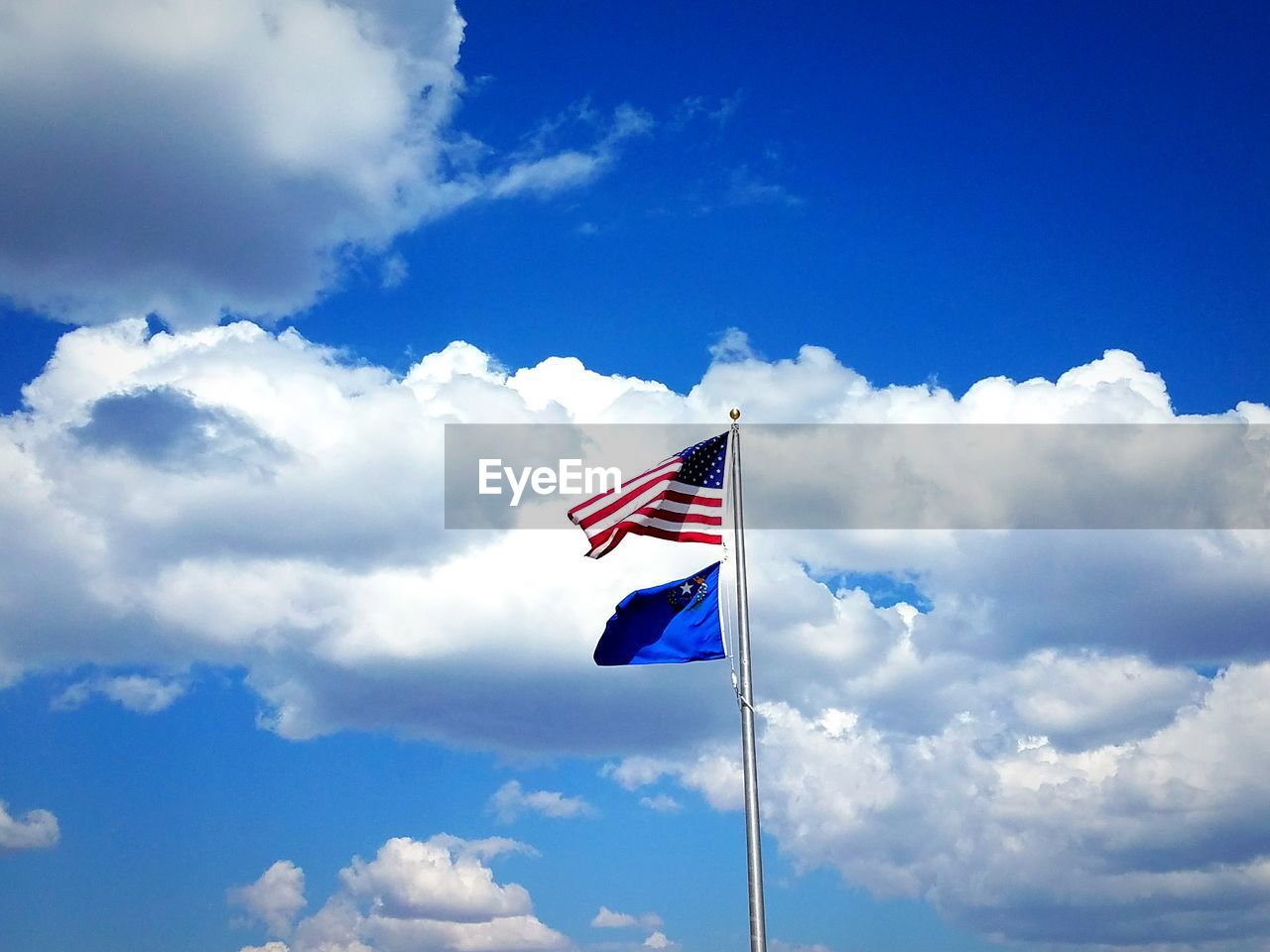 Country flag above state flag in the blue sky
