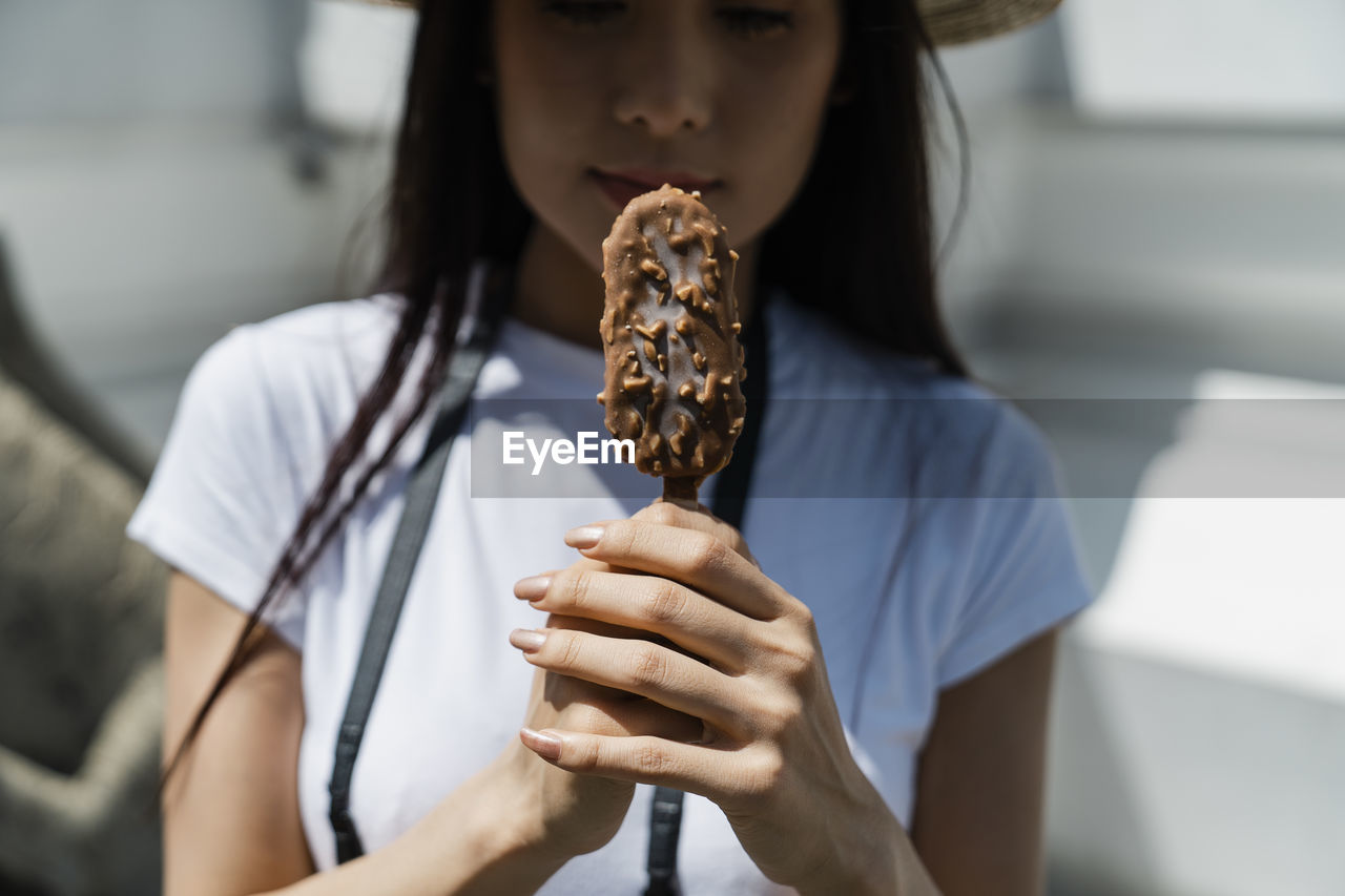 Woman holding ice cream in city