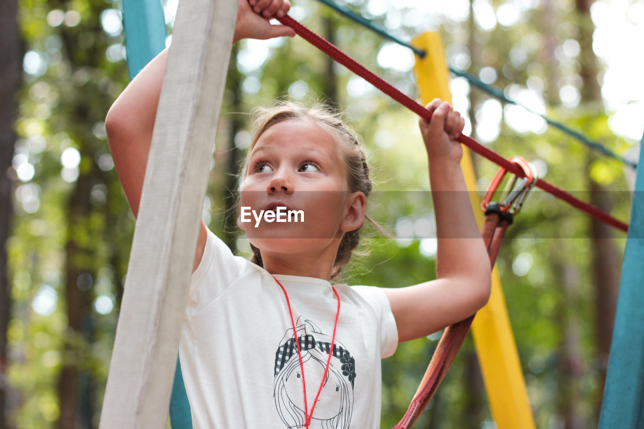 Low angle view of girl doing zip lining at playground