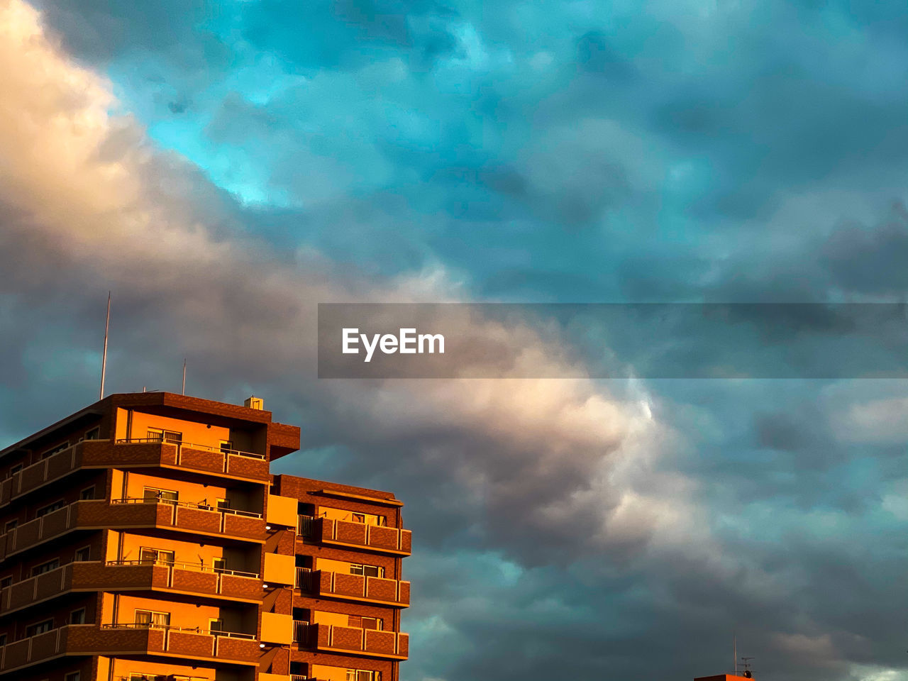 Low angle view of buildings against dramatic sky