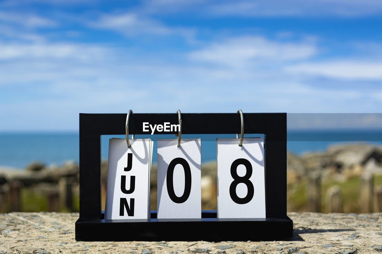 Jun 08 calendar date text on wooden frame with blurred background of ocean. calendar date concept.