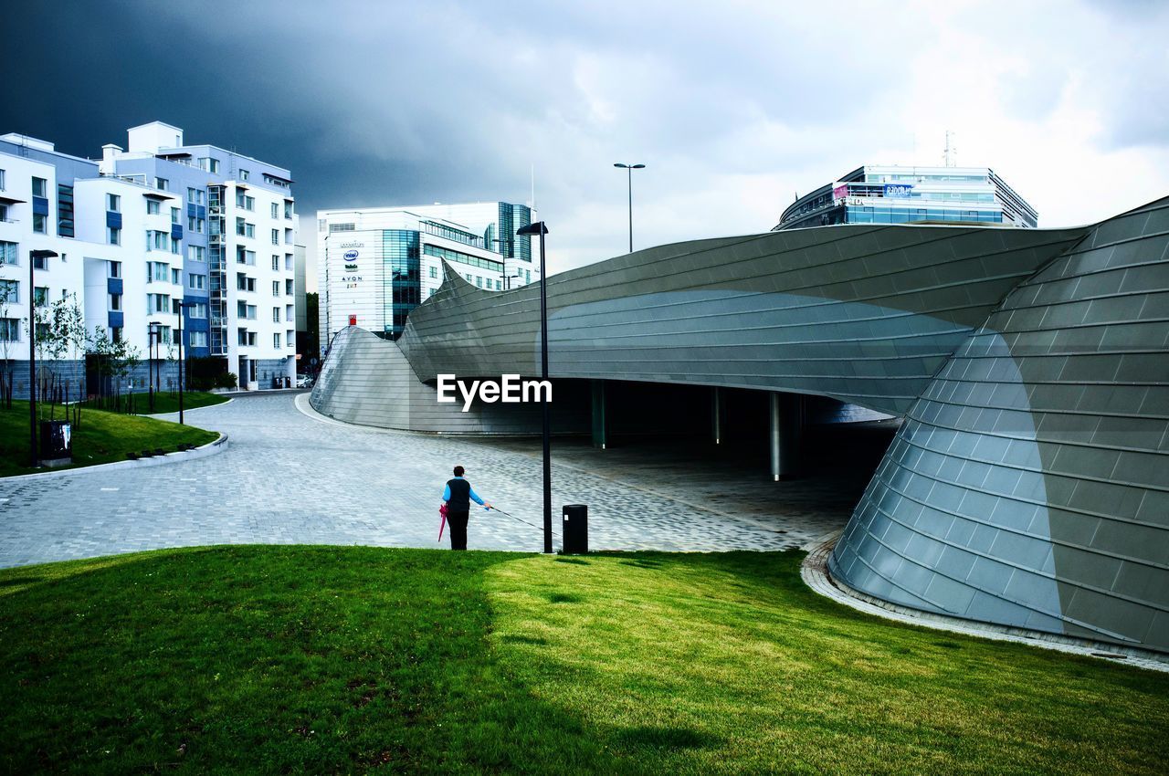 MAN IN FRONT OF BUILDING