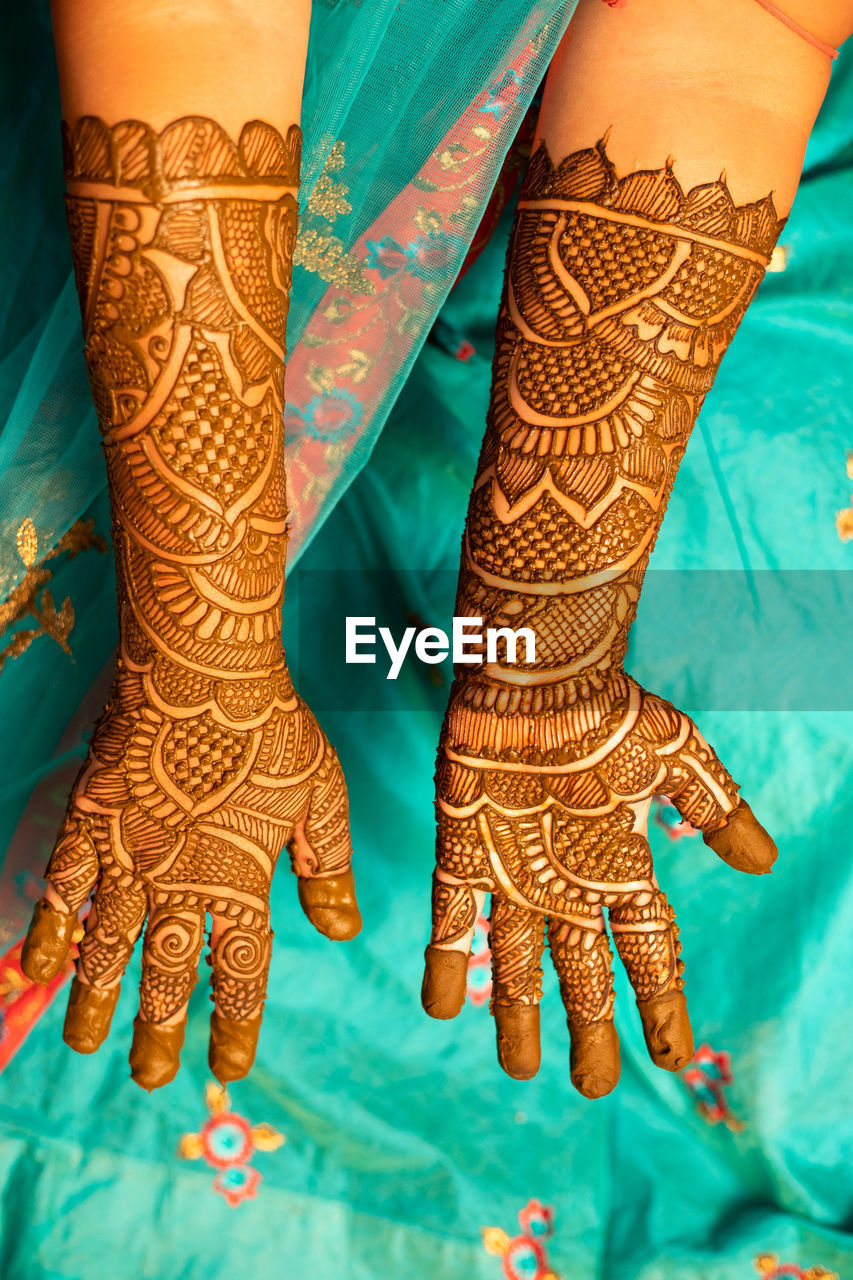 Midsection of bride showing henna tattoo