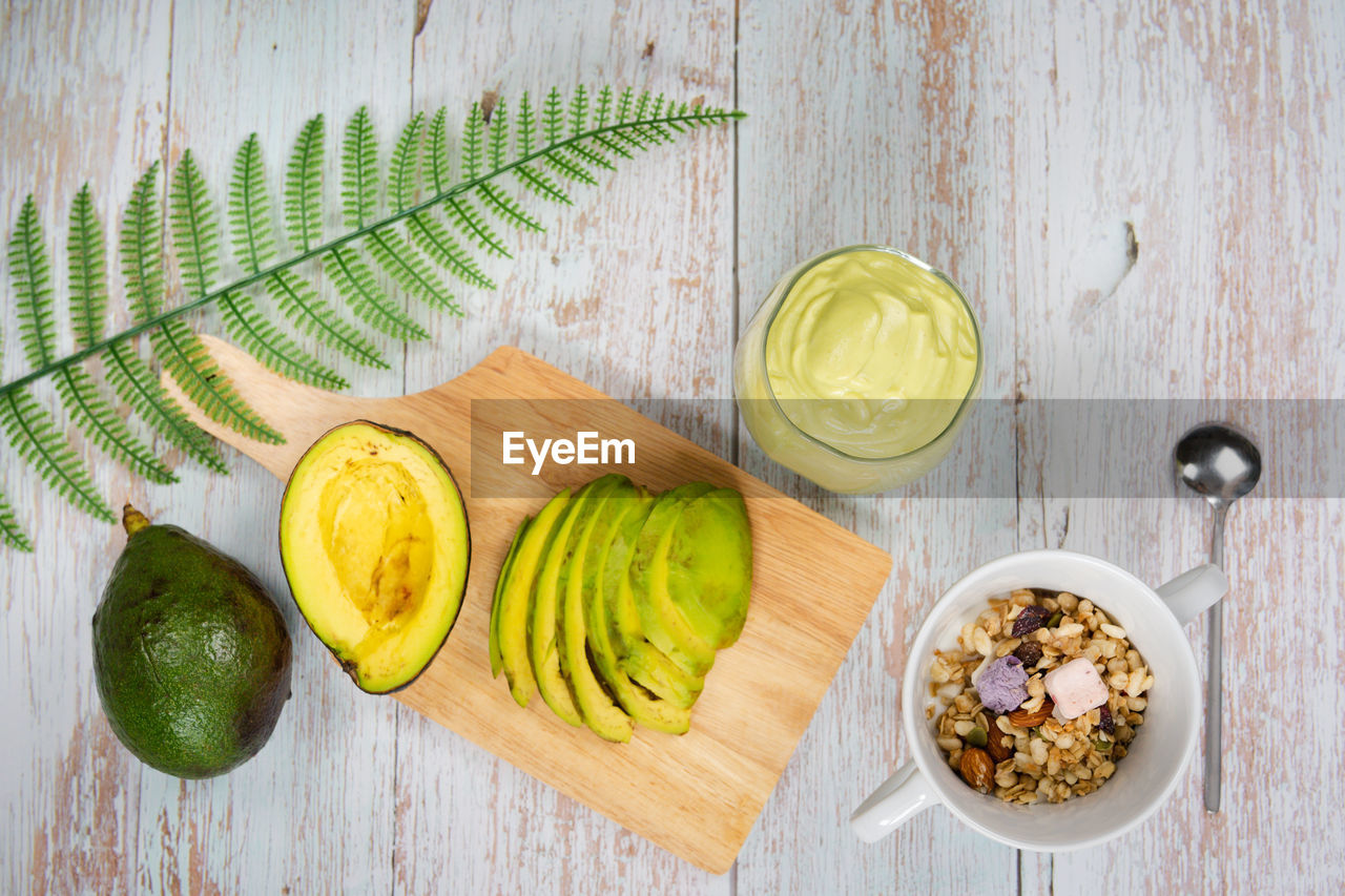 Healthy eat and lifestyle with avocado slice ,smoothie and breakfast on wooden background