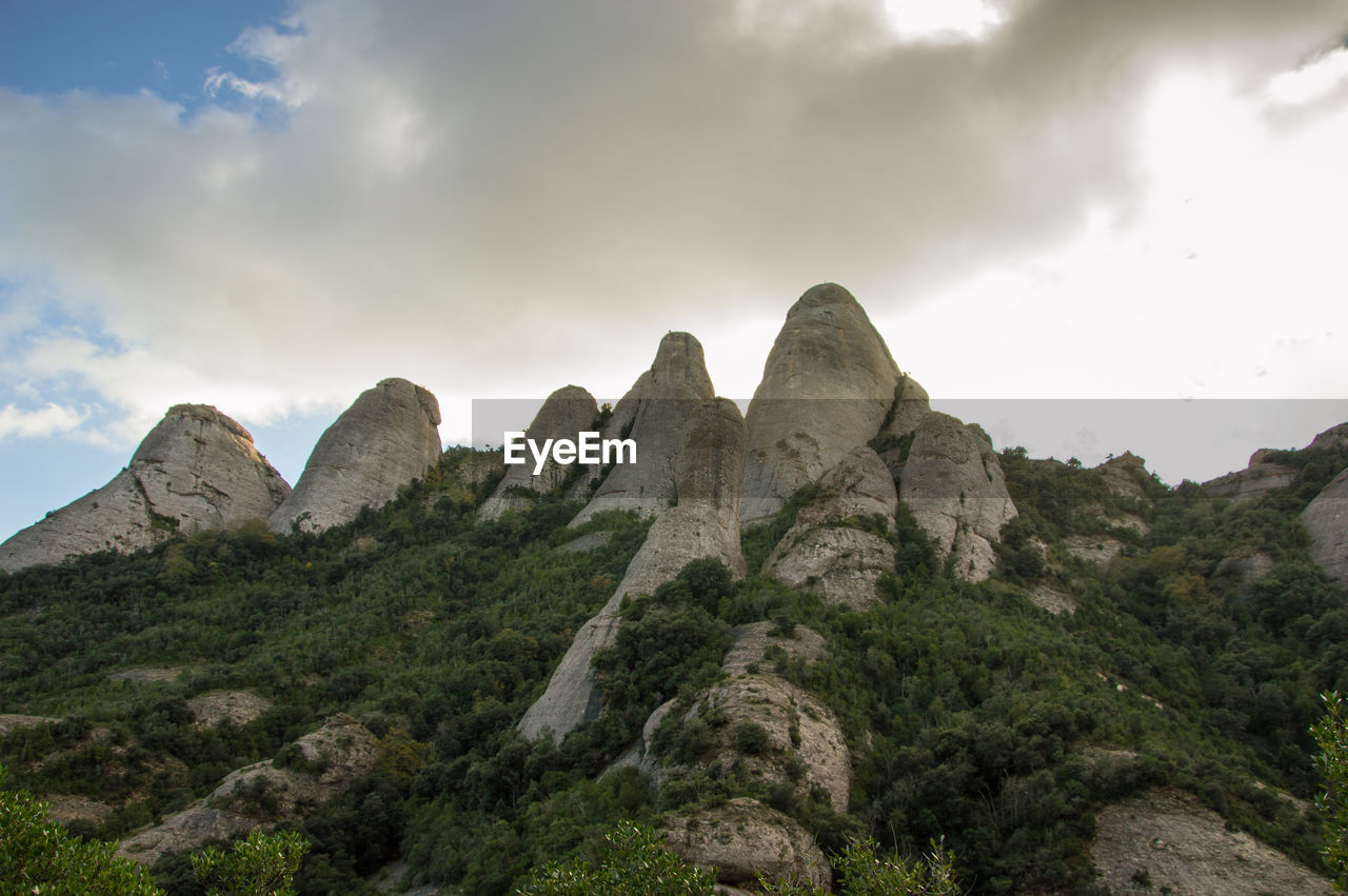 Scenic view of rocky mountains against cloudy sky