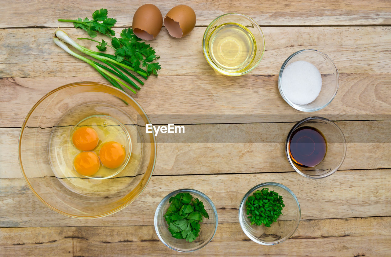 Directly above shot of egg yolks with various ingredients on table
