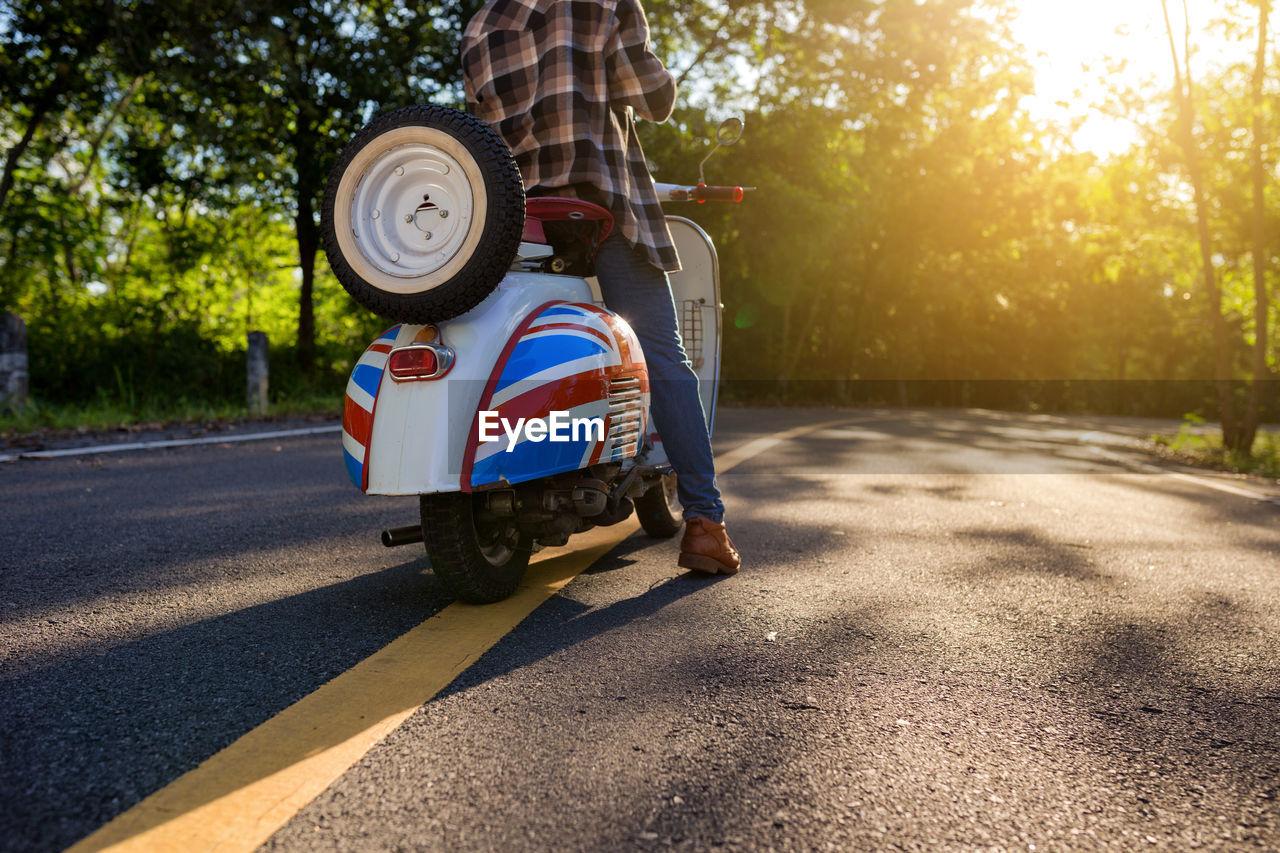 Close-up of man with scooter on road