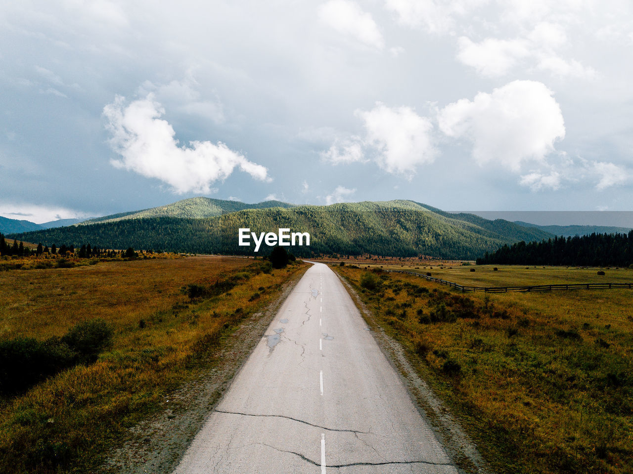 Empty road along landscape against sky