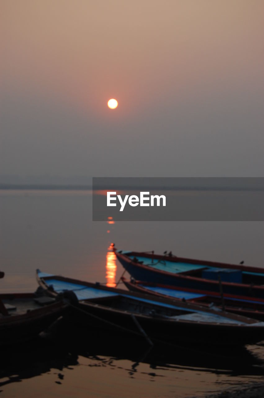 BOAT MOORED ON SEA AT NIGHT