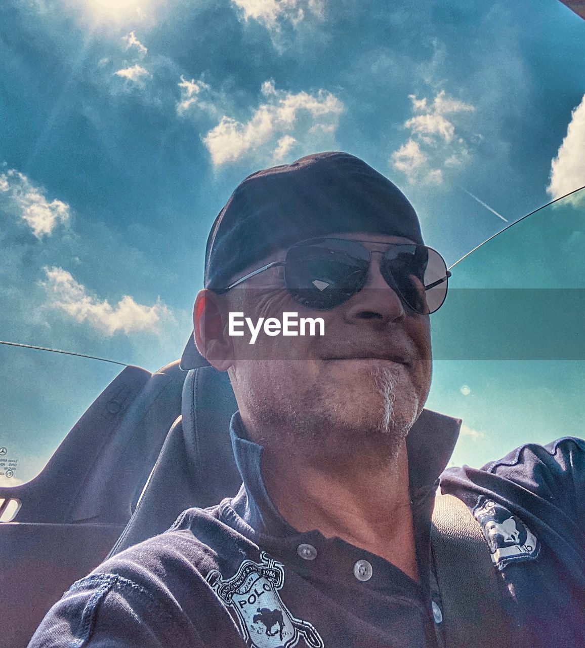 LOW ANGLE VIEW OF MAN WEARING SUNGLASSES AGAINST SKY