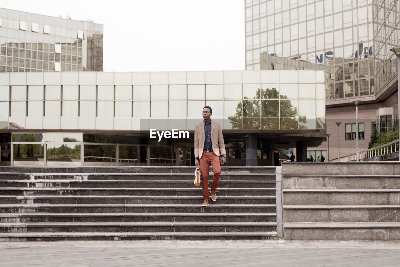 Businessman moving down steps in city