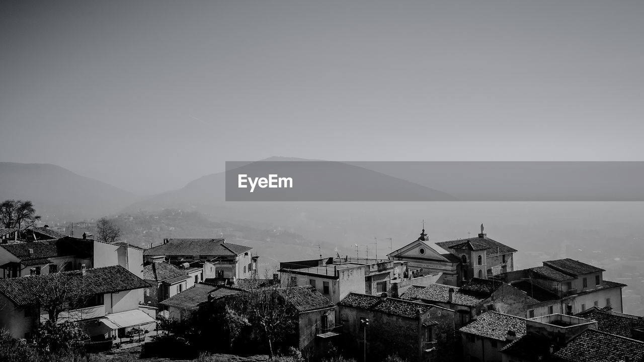 HIGH ANGLE VIEW OF BUILDINGS IN CITY AGAINST CLEAR SKY