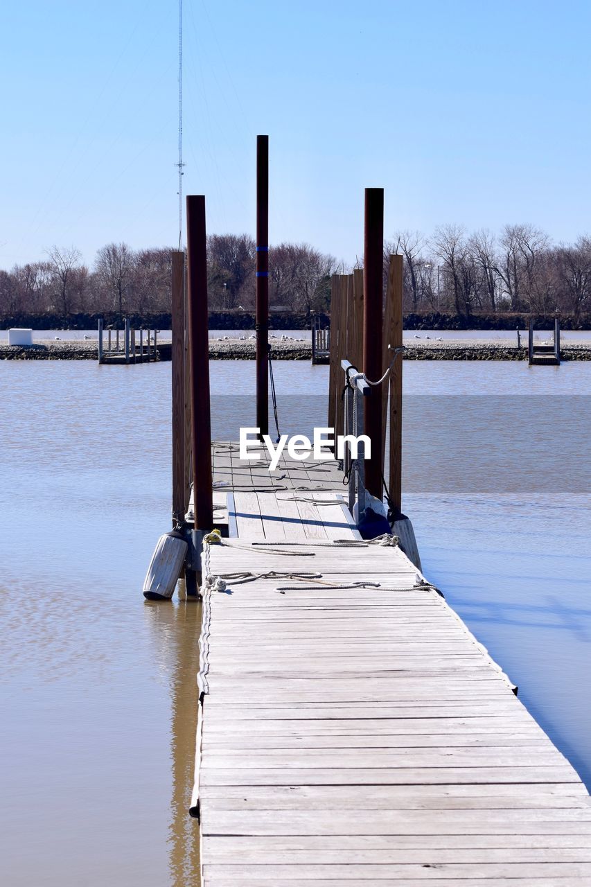 Wooden pier over lake against sky during winter