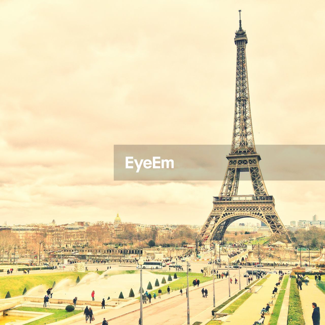 Eiffel tower in city against cloudy sky