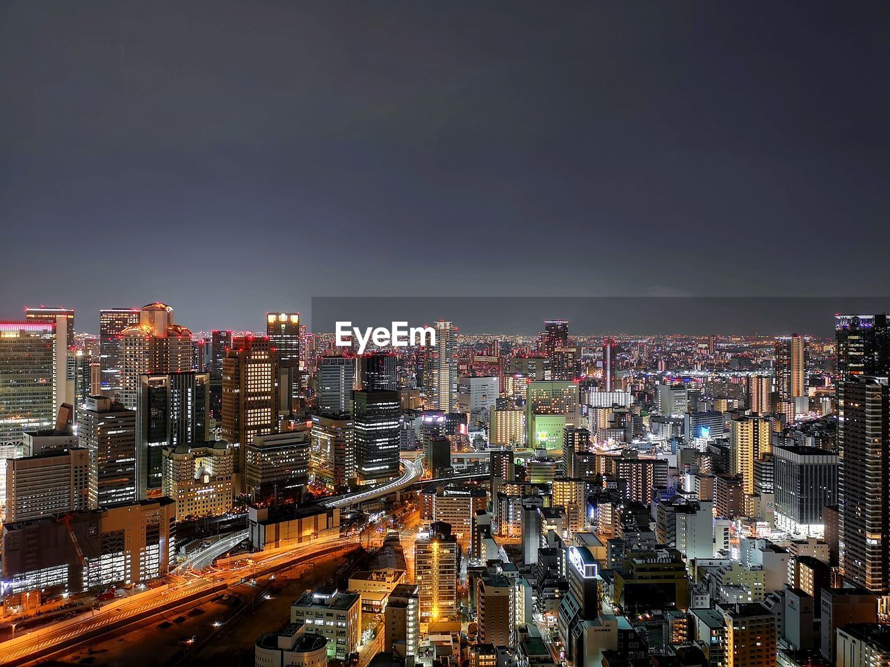 Illuminated cityscape against sky at night