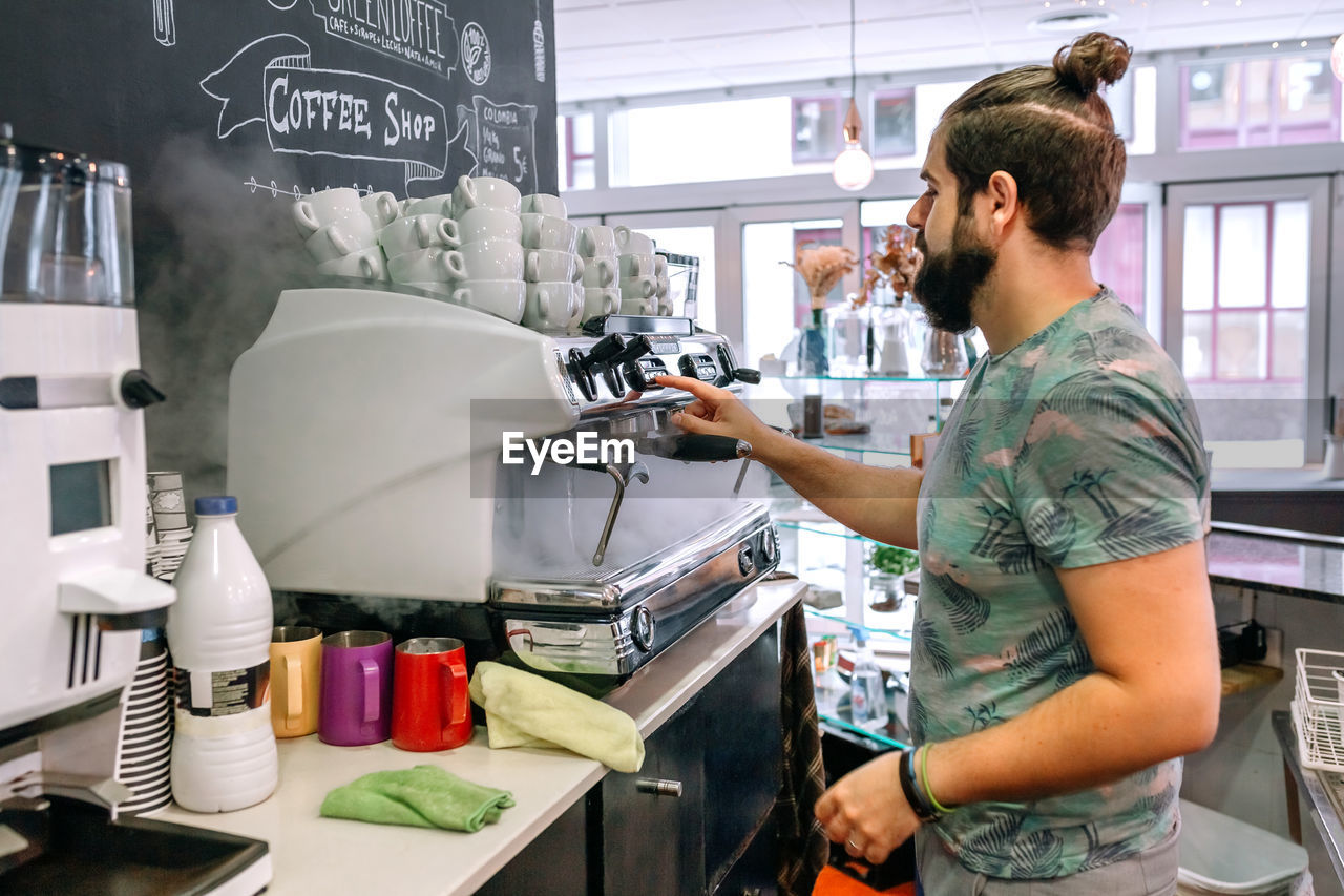 SIDE VIEW OF A YOUNG MAN STANDING BY STORE