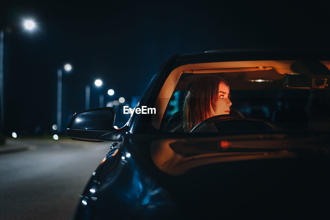 Young woman in car at night