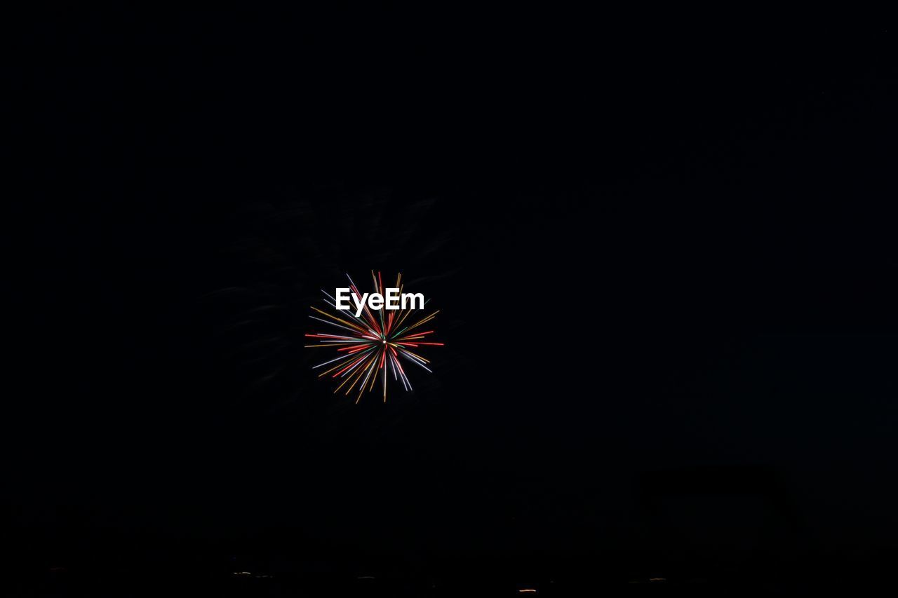 Low angle view of firework display against clear sky at night