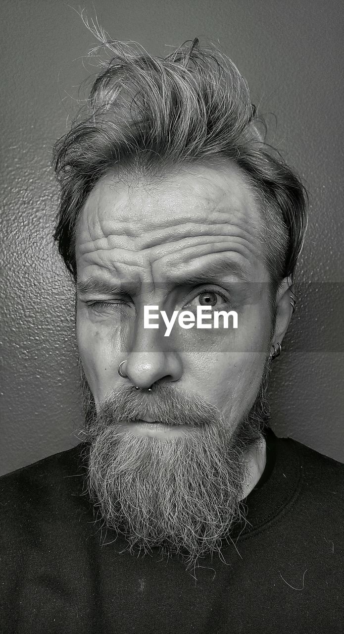 portrait, facial hair, beard, human hair, one person, black and white, adult, headshot, indoors, men, looking at camera, monochrome, moustache, mature adult, human face, hairstyle, front view, monochrome photography, lifestyles, close-up, human head, studio shot, black, person, gray, serious, gray background