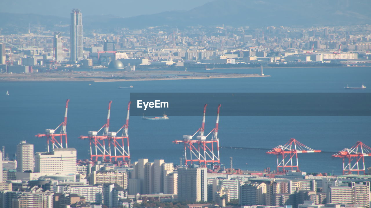 Aerial view of buildings in city against sky