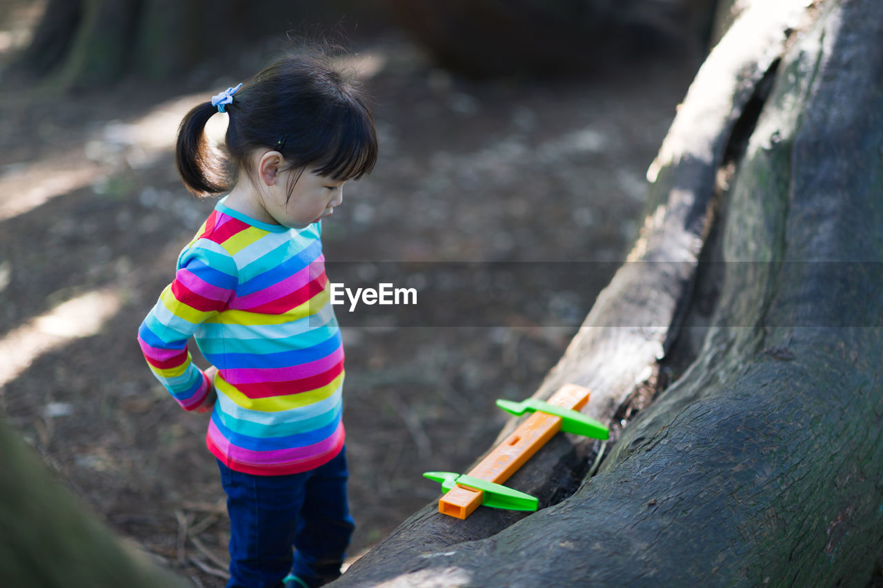 Young girl playing outdoor measure-mate in the forest park for leaning measurement