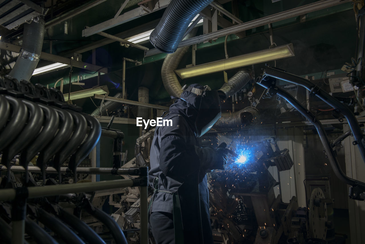 Worker welding at factory