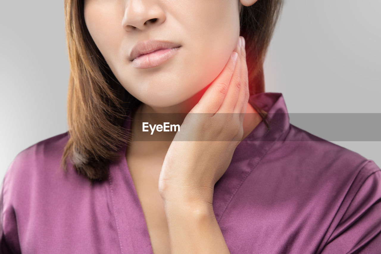 Close-up of woman touching neck