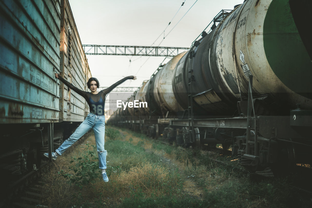 Portrait of woman hanging on train at shunting yard