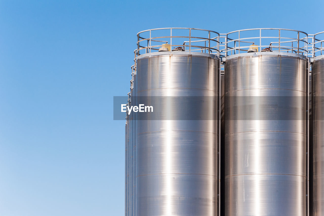Silos in factory against sky