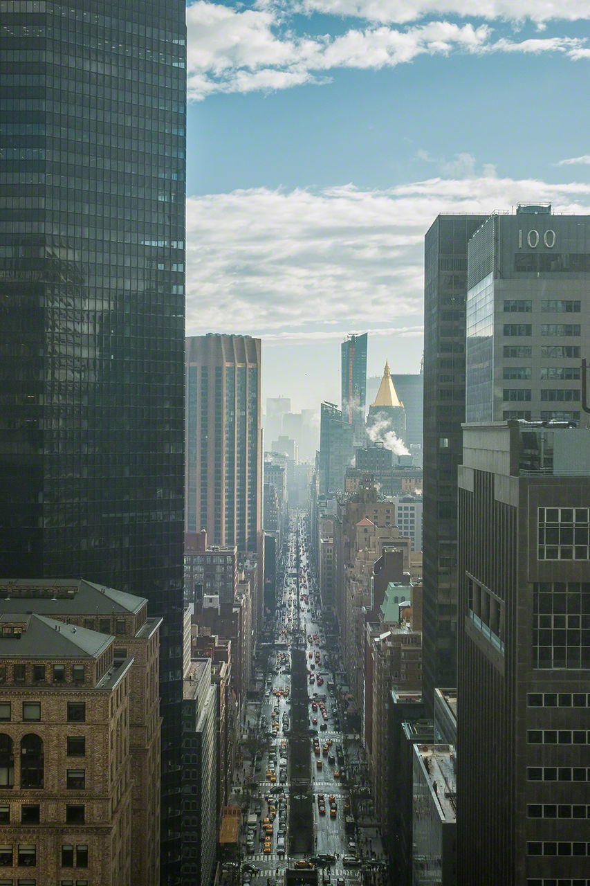 Skyscrapers in city against cloudy sky