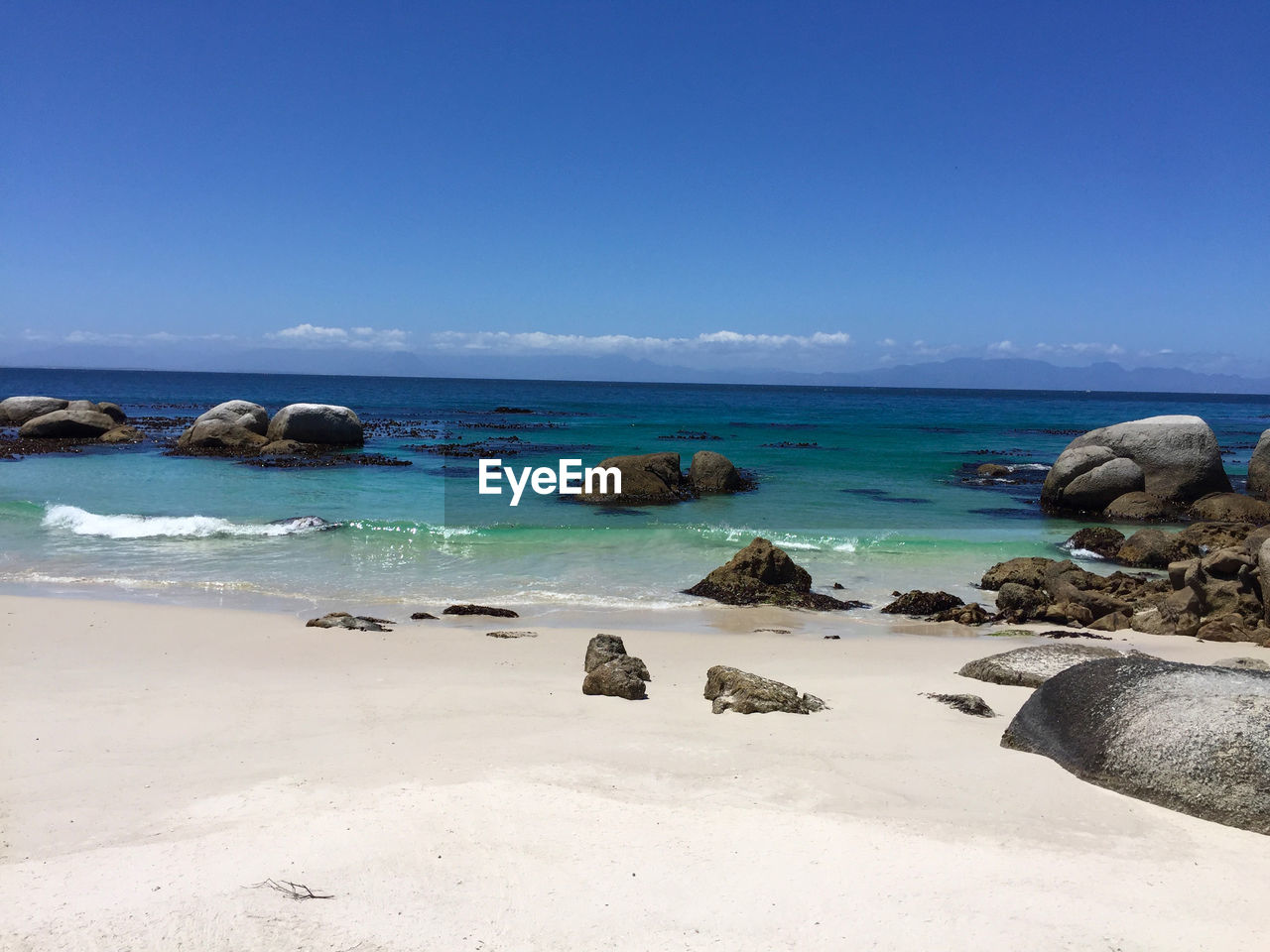 Scenic view of beach against blue sky