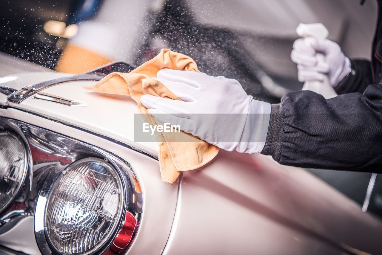 Midsection of person cleaning car