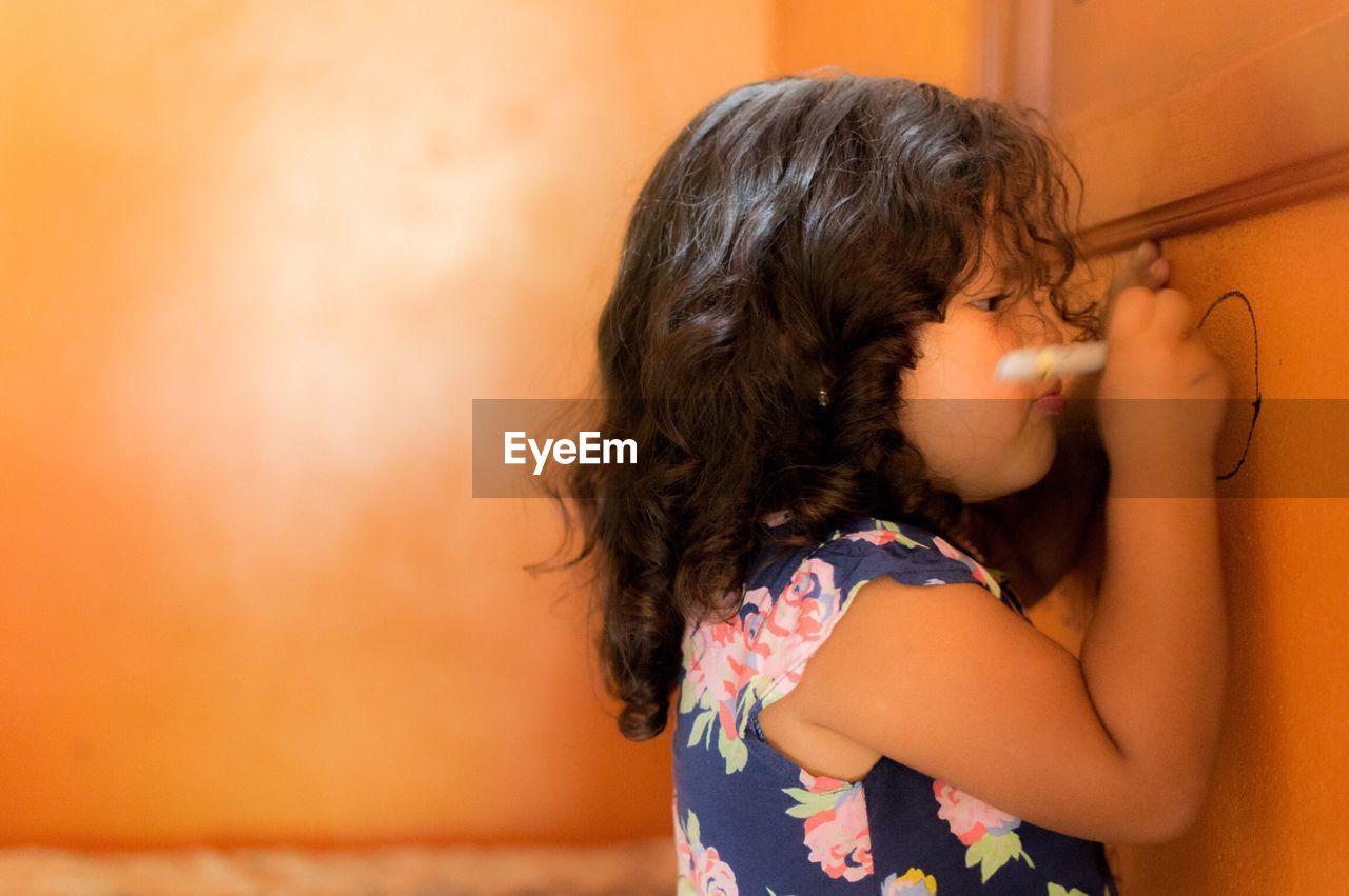 CLOSE-UP OF GIRL LOOKING AWAY WHILE RELAXING AT HOME