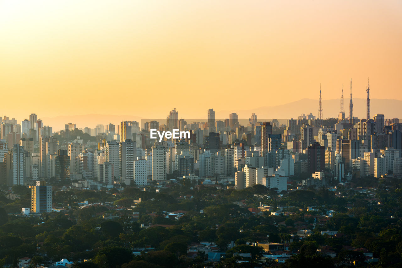 Modern buildings against sky during sunset in city