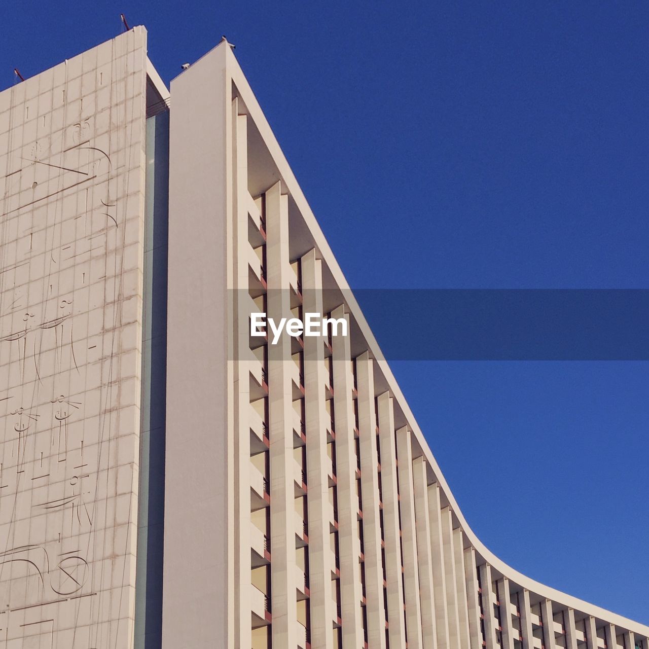 Low angle view of building against clear blue sky