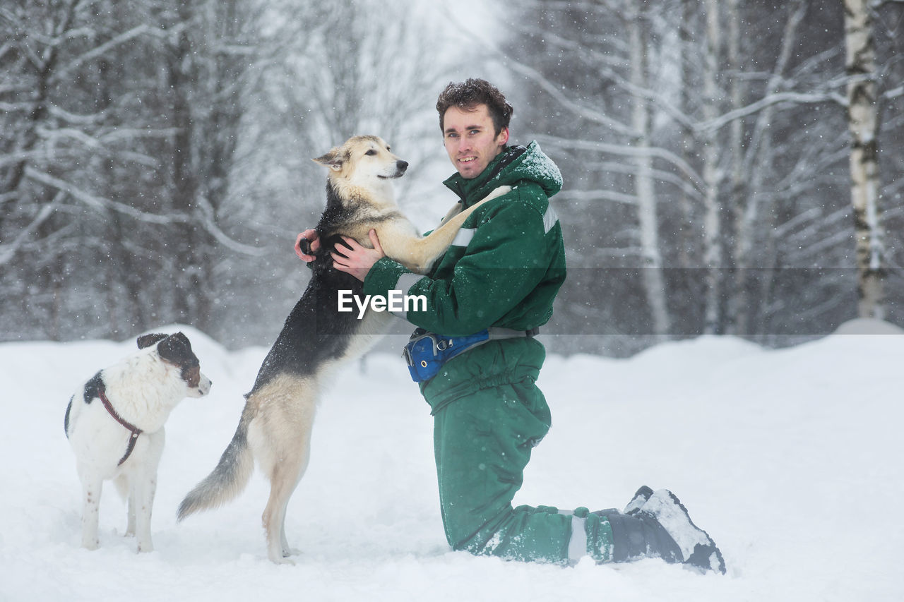 Full length of man with dogs during winter