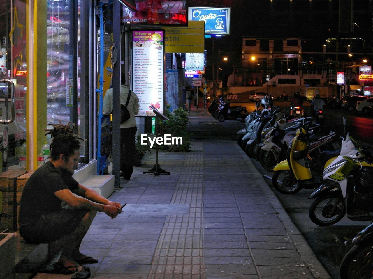 MEN IN ILLUMINATED CITY