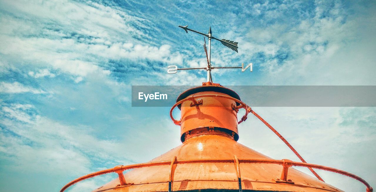 Low angle view of weather vane against sky