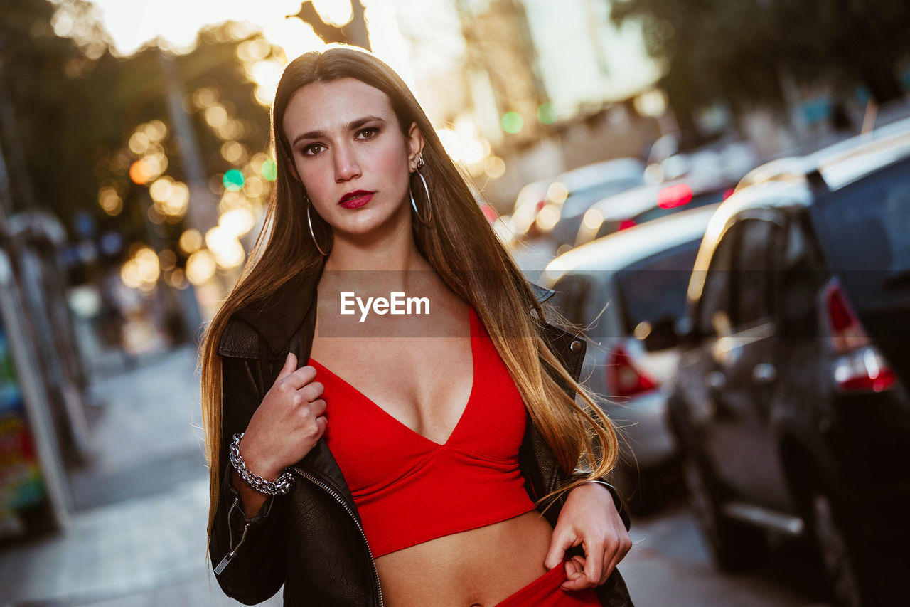 Portrait of beautiful young woman standing in city